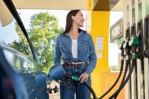 Happy,european,lady,refueling,her,car,at,modern,petrol,station